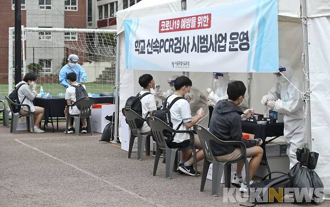 서울 종로구 동성고등학교에 마련된 '학교 신속PCR검사 시범사업 운영소'에서 검체를 채취하고 있다.   사진공동취재단