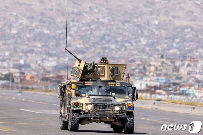 (카불 AFP=뉴스1) 우동명 기자 =  13일(현지시간) 아프가니스탄 카불 공항에서 탈레반 병사가 무장한 차량을 타고 순찰하고 있다.  (C) AFP=뉴스1