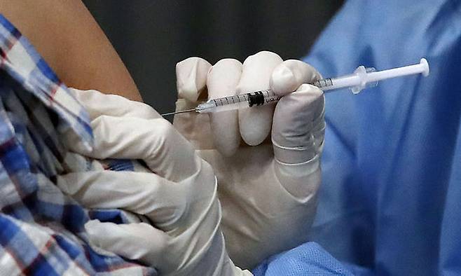 30일 오후 서울 송파구 체육문화센터에 마련된 예방접종센터에서 한 시민이 백신 접종을 받고 있다. 뉴시스