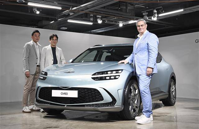 제네시스 관계자들이 30일 세계 최초로 공개된 전기차 GV60과 함께 기념사진을 찍고 있다. 왼쪽부터 이시혁 상무, 윤일헌 상무, 루크 동커볼케 부사장. 제네시스 제공