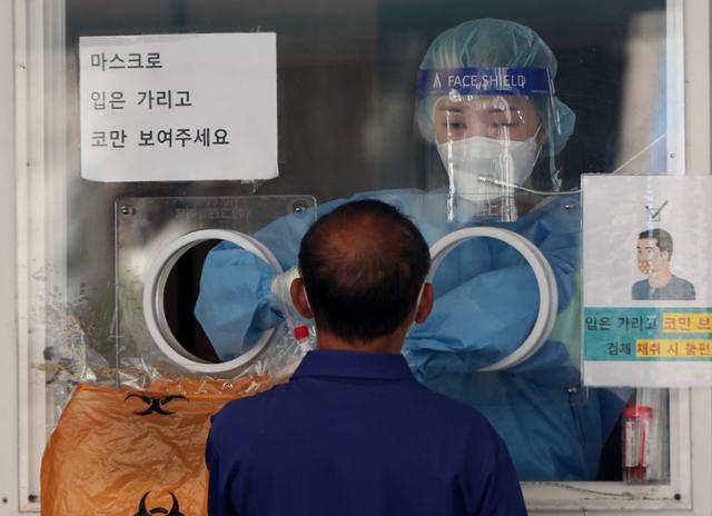 1일 중구 서울역광장에 설치된 코로나19 임시선별검사소에서 의료진이 검체채취를 하고 있다. 뉴시스