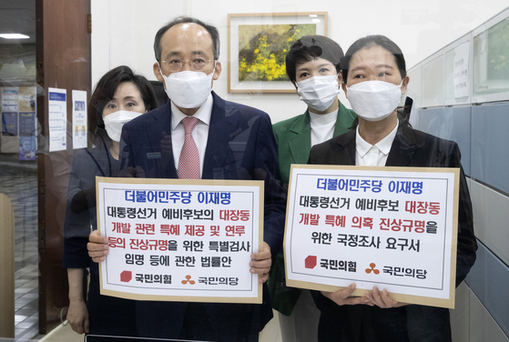 From left: People Power Party lawmakers Jun Ju-hyae, Choo Kyung-ho, Kim Eun-hye and People's Party lawmaker Kwon Eun-hee hold placards at the National Assembly on Thursday morning as they submit a proposal to create a parliamentary probe into Gyeonggi Governor Lee Jae-myung's connection to the Daejang-dong development project. [LIM HYUN-DONG]