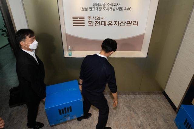 서울중앙지검 대장동 개발의혹 사건 전담수사팀이 지난달 29일 오후 경기 성남시 분당구 자산관리사 화천대유 사무실에서 대장동 개발사업의 특혜 의혹과 관련한 압수수색을 마친 뒤 압수품을 옮기고 있다. 뉴시스