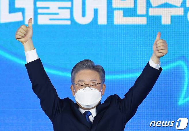 더불어민주당 제20대 대통령선거 후보에 선출된 이재명 경기지사가 10일 오후 서울 송파구 올림픽공원 SK올림픽핸드볼경기장에서 열린 서울 지역 경선 및 3차 국민선거인단 투표에서 손을 들고 인사하고 있다. 이 후보는 서울 지역 경선에서 51.45%를 얻어 누적 득표율 50.29%를 기록, 결선 투표 없이 더불어민주당 20대 대통령 선거 후보에 선출됐다. 2021.10.10/뉴스1 © News1 국회사진취재단