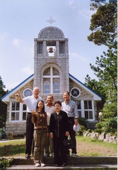 진요한(윗줄 맨 왼쪽) 신부가 신자들과 몽돌로 지은 흑산도성당 앞에서 사진을 찍었다. 사진 성골롬반외방선교회 제공