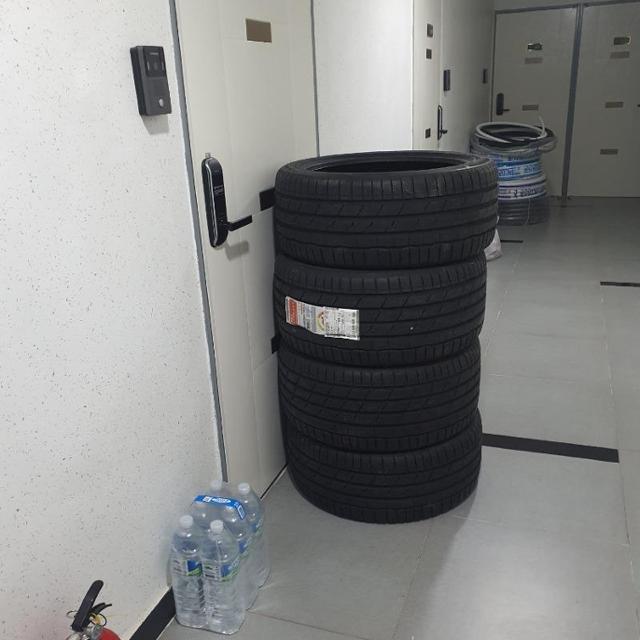 한 누리꾼이 12일 온라인 커뮤니티 사이트에 올린 사진으로, 현관문을 열 수 없을 정도로 문 앞에 차량 타이어 네 개가 쌓여 있는 모습. 보배드림 캡처