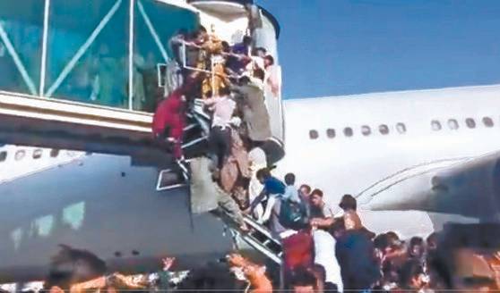 이슬람 무장단체 탈레반이 정권을 재장악하면서 지난 8월 16일 수도 카불 공항에서 아프가니스탄을 탈출하려는 사람들이 항공기 탑승 계단에 매달려 혼잡을 이루고 있다. [트위터 캡처]
