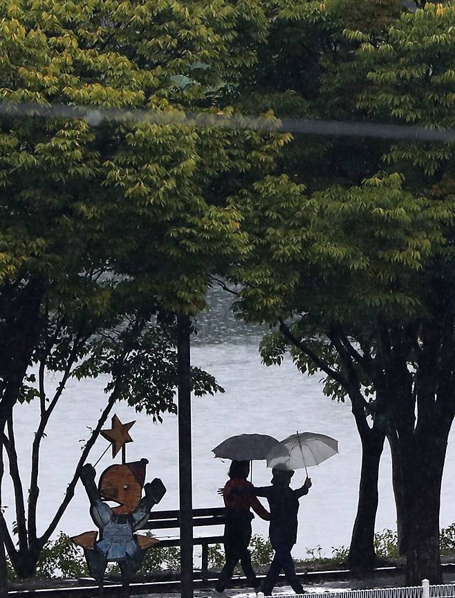지난 15일 강원 춘천시 공지천 산책로에서 우산을 쓴 시민이 발걸음을 옮기고 있다. [사진 출처=연합뉴스]