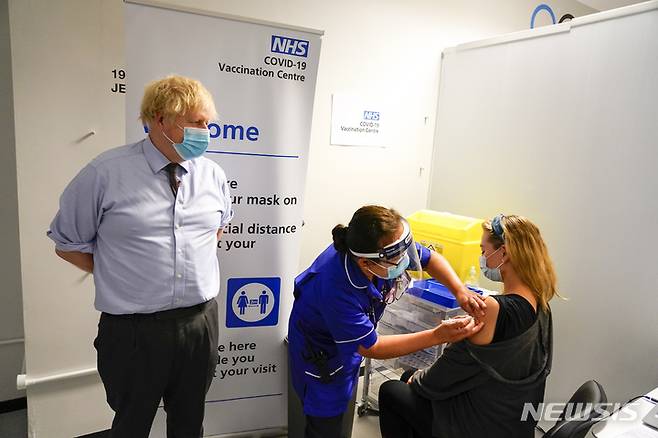 [AP/뉴시스} 6월 자료사진으로 보리스 존슨 영국 총리가 런던의 한 접종 센터를 찾아 참관하고 있다.