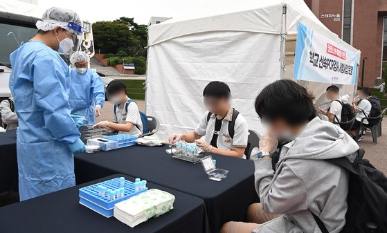 9월 28일 오전 서울 종로구 동성고등학교에서 학생들이 등교하며 '신속 자가분자진단 유전자증폭(신속 PCR)' 및 타액을 통한 코로나19 검사를 받고 있다. 뉴스1