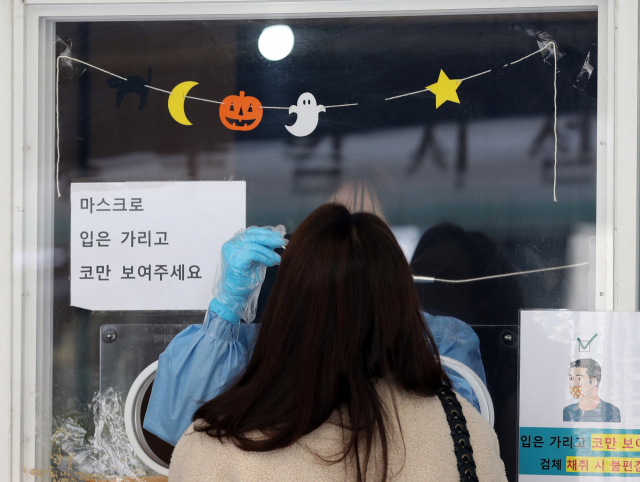18일 오전 서울역 광장에 마련된 중구임시선별검사소에서 시민들이 검사를 받고 있다./연합뉴스