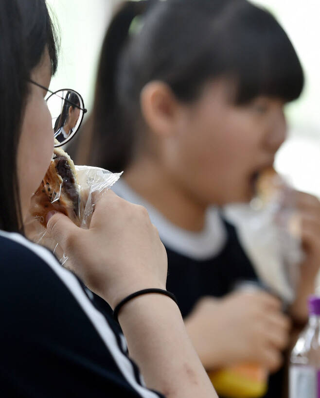 전국 학교비정규직노조의 2019년 7월 총파업으로 급식이 중단되면서 학교에서 학생들이 빵과 음료를 먹으며 점심을 해결하고 있다.(사진=뉴시스)