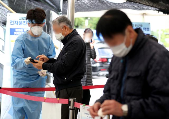 18일 오전 서울 마포구보건소에 설치된 코로나19 선별진료소에서 시민들이 검사를 받기 위해 준비하고 있다. 뉴스1