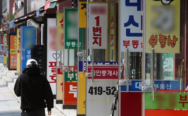 부동산 중개보수를 대폭 낮추는 이른바 '반값 복비' 시행 첫날인 19일 서울 송파구의 중개업소들 앞으로 한 시민이 걸어가고 있다. 뉴시스