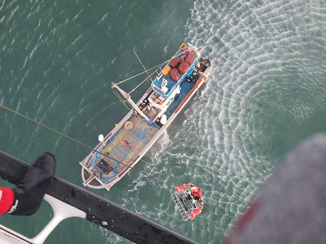 지난 18일 어선이 전복돼 바다에 빠졌던 선원을 헬기로 올리고 있다.|인천 해양경찰서 제공