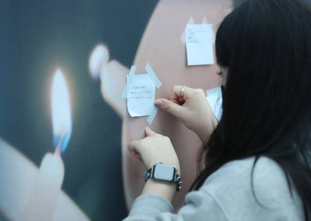 ▲ 15일 오후 광주 동구 5·18 민주광장에서 열린 고(故) 홍정운 군 추모 촛불집회에서 한 시민이 추모하는 글을 붙이고 있다. ⓒ연합뉴스