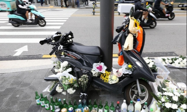 지난 8월 27일 서울 강남구 선릉역 앞에서 열린 '선릉역 오토바이 라이더의 추모행동'에 마련된 고인의 오토바이 옆을 지나고 있다. 뉴시스
