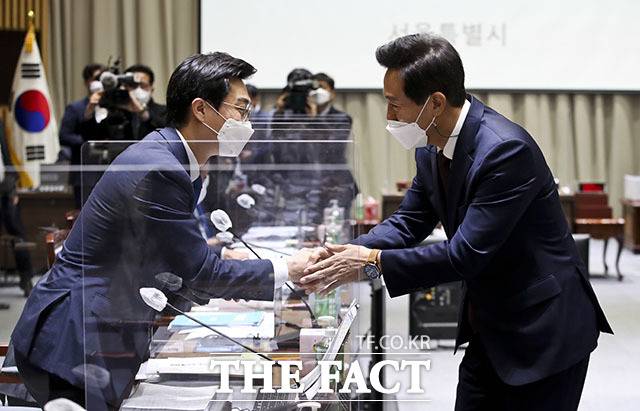 국정감사에 앞서 더불어민주당 장경태 의원(왼쪽)과 인사를 하는 오세훈 시장.