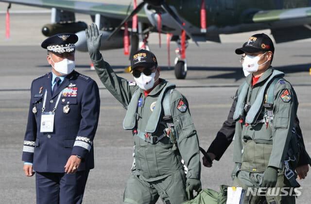 문재인 대통령이 20일 2021 서울 국제 항공우주 및 방위산업 전시회 기념식이 열린 경기도 성남시 서울공항에서 FA-50 경공격기에 탑승해 비행을 마치고 이동하며 참석자들에게 손을 들어 인사하고 있다.(사진=뉴시스)