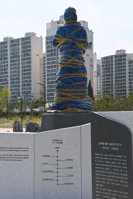 지난 7월 설치 됐으나 관련 단체 간 명칭 시비로 공개되지 못한 채 비닐에 감싸져 있는 김주열 열사 동상.