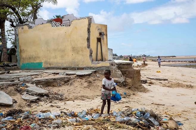 2019년 모잠비크에 내린 기록적인 홍수로 폐허가 된 거리에서 한 아이가 쓰레기를 줍고 있다./AFP 연합뉴스
