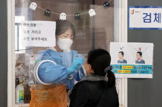 지난 19일 서울역광장에 마련된 코로나19 임시선별검사소에서 의료진이 검체를 채취하고 있다. [이미지출처=연합뉴스]
