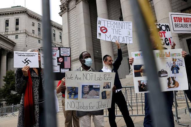 지난 12일 뉴욕시 맨해튼의 법원 앞에서 백신 의무화 조치에 반대하는 시위대가 "우리는 실험실의 쥐가 아니다" "백신 의무화는 나치 같은 짓"이란 팻말을 들고 시위하고 있다. /로이터 연합뉴스