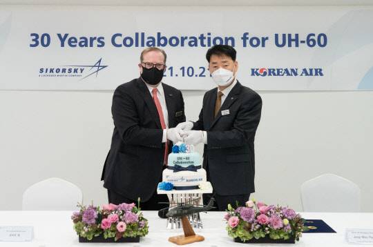 사진은 박정우 대한항공 항공우주사업본부 본부장(오른쪽)과 로버트 랭(Robert Laing) 록히드마틴 한국지사장(왼쪽)이 기념 사진을 촬영하고 있는 모습. <대한항공 제공>