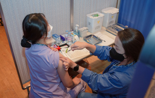 부산의 한 간호사가 코로나 백신 부스터샷을 접종하고 있다. 부산대병원
