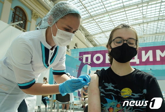 러시아 모스크바에서 한 여성이 스푸트니크V 코로나19 백신을 맞는 모습. 블라디미르 푸틴 대통령은 오는 30일부터 11월 7일까지 비필수 매장의 휴무를 지시했다./사진=로이터/뉴스1