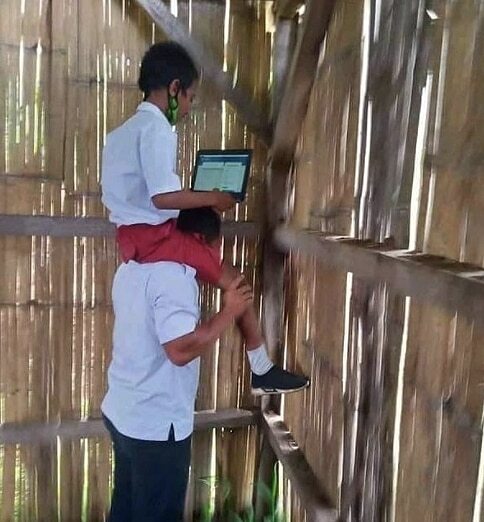 인터넷 신호를 잡기 위해 교사의 목말을 탄 인도네시아 초등학생./nttupdate 인스타그램