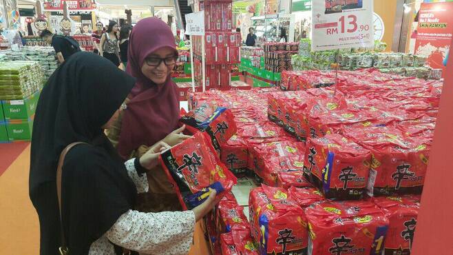 말레이시아의 한 대형마트에서 할랄 인증을 받은 '신라면'을 현지 소비자들이 구매하고 있다. /농심