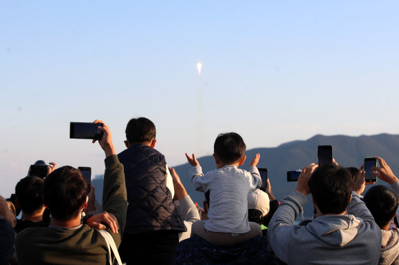 고흥 봉남등대 전망대에서 시민들이 하늘을 향해 날아오르는 누리호를 휴대전화 카메라에 담는 모습.연합뉴스