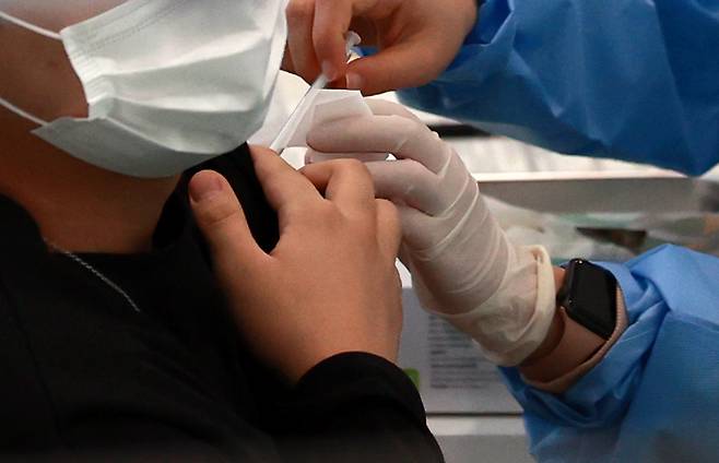 23일 오전 서울 관악구민종합체육센터에 마련된 신종 코로나바이러스 감염증(코로나19) 백신 접종센터를 찾은 시민이 백신 접종을 받고 있다. [연합]