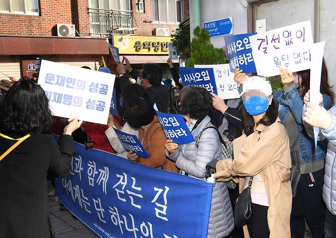 24일 오후 더불어민주당 대선 후보인 이재명 경기도지사와 이낙연 전 대표의 회동 장소인 서울 종로구 안국동 한 찻집 인근에 양측 지지자들이 손팻말을 들고 있다. [연합]