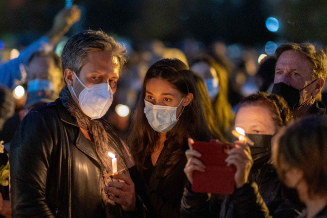 24일(현지시간) 미국 캘리포니아 버뱅크에서 총기사고로 사망한 할리나 허친스 촬영감독을 추모하는 촛불집회가 열린 가운데 시민들이 애도하고 있다. 버뱅크 | AFP연합뉴스