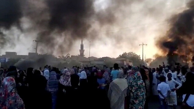 군사 쿠데타가 발생한 것으로 알려진 25일, 수단 수도 하르툼 거리에 시민들이 몰려나온 가운데 불타는 타이어에서 연기가 솟고 있다. 로이터 연합뉴스