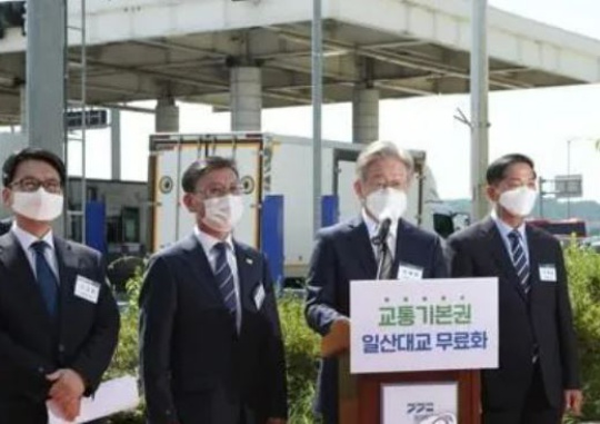 Gyeonggi Governor Lee Jae-myung (second from right) gives a briefing on plans for a disposition for public interest for free passage on the Ilsan Bridge in front of the Ilsan Bridge toll booths in Gimpo-si, Gyeonggi-do on September 3. Yonhap News