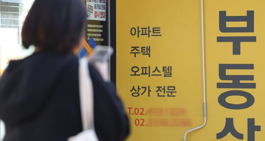 한 시민이 부동산공인중개업소 앞에서 매물 정보를 검색하고 있다. <연합뉴스>