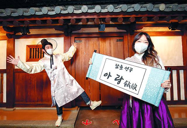 롯데월드의‘아랑: 굶주린 이리’방탈출에 성공한 뒤 인증샷을 남기는 이용객. 롯데월드 제공