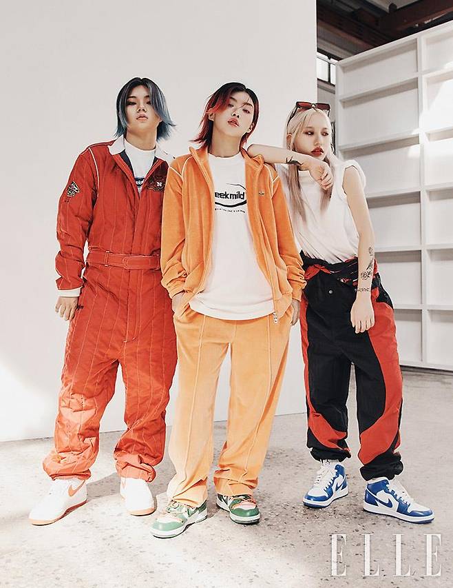 뤠이젼이 입은 레드 점프수트는 Beyond by Navy. 슈즈는 Nike. 아이키가 입은 오렌지 트레이닝 재킷과 팬츠는 모두 Lacoste Live. 티셔츠는 Meek Mild. 슈즈는 Nike. 오드가 입은 로고 티셔츠는 Meek Mild. 스퀘어 선글라스는 Gentle Monster. 팬츠와 슈즈는 모두 Nike.