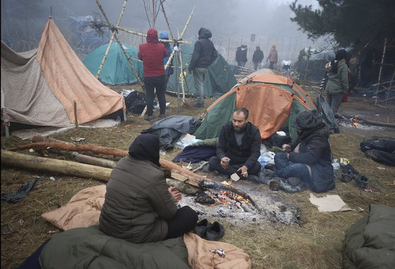 폴란드와 벨라루스 국경에 텐트를 치고 장작을 불태우고 있는 중동 난민들. [AP=연합뉴스]
