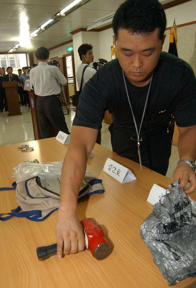 연쇄살해범 유영철 검거 관련 브리핑이 열린 2004년 7월 18일 시경에서 브리핑에 앞서 범인이 사용한 둔기를 공개하고 있다. 한국일보 자료사진