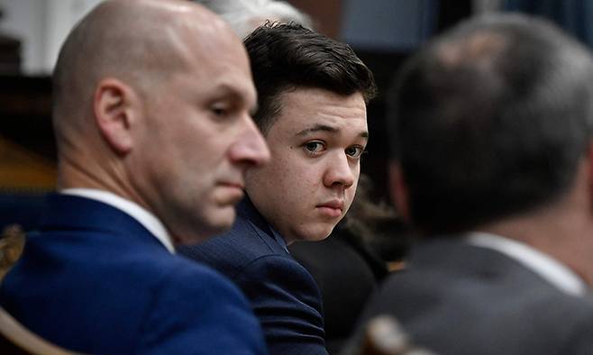 인종차별 반대 시위대에 총을 쏴 2명을 살해하고, 1명을 다치게 한 혐의로 기소된 카일 리튼하우스(가운데)가 지난 18일 (현지시간) 위스콘신주 커노샤 카운티 법원에서 열린 공판에서 변호사를 바라보고 있다. 이튿날 그는 무죄 평결을 받았다. 커노샤=AFP연합뉴스