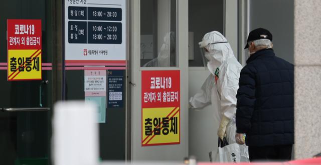 26일 오후 서울 은평구 서울시립서북병원에 코로나19 환자가 도착해 의료진의 안내를 받고 있다. 뉴스1