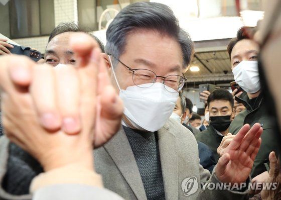 이재명 민주당 후보가 26일 오전 전남 목포 동부시장을 방문해 시민들과 손을 붙잡고 인사하고 있다. 연합뉴스