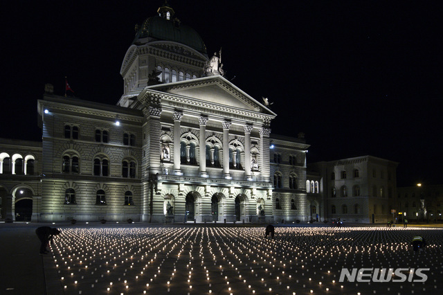 [베른=AP/뉴시스]21일(현지시간) 스위스 수도 베른의 연방 의회 앞 분데스플라츠에서 활동가들이 코로나19로 사망한 사람들을 기리기 위해 약 9200개의 촛불을 밝히고 있다. 2021.02.22.