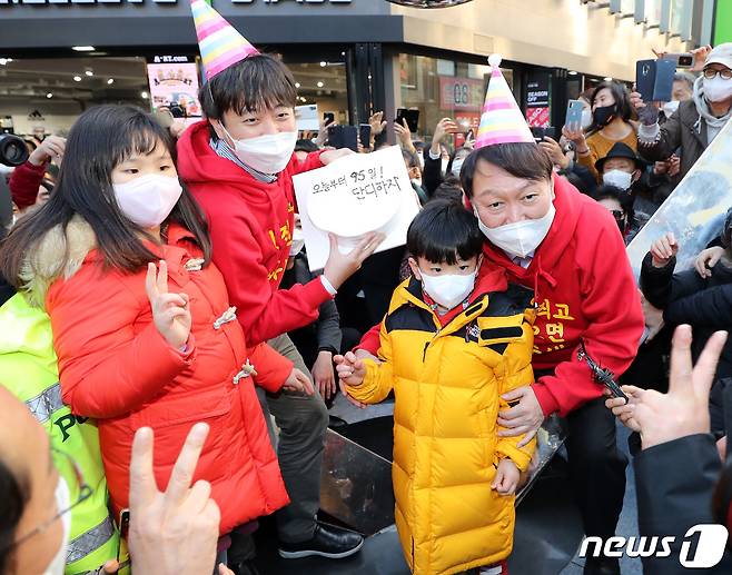 윤석열 국민의힘 대선 후보가 4일 오후 부산 서면 젊음의 거리에서 이준석 대표와 어린이들로부터 생일케이크를 받고 함께 기념 사진을 찍고 있다. 생일 케이크에는 '오늘부터 95일 단디하자'라는 문구가 적혀 있다. 2021.12.4/뉴스1 © News1 구윤성 기자