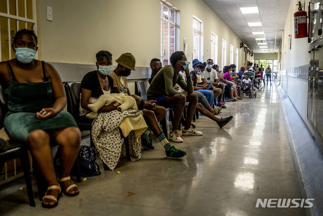 [요하네스버그=AP/뉴시스] 지난 1일(현지시간) 남아프리카공화국 요하네스버그 인근 한 병원에 코로나19 백신을 접종하려는 시민들이 줄지어 앉아 있다. 2021.12.05.