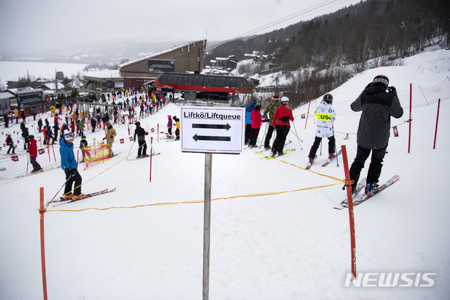[아레=AP/뉴시스] 2020년  12월30일 스웨덴 아레에 있는 스키장에서 스키를 타려는 사람들이 코로나19 확산 방지를 위해 사회적 거리 두기를 유지한 채 리프트를 타기 위해 줄 서 있다.  2020.12.30.